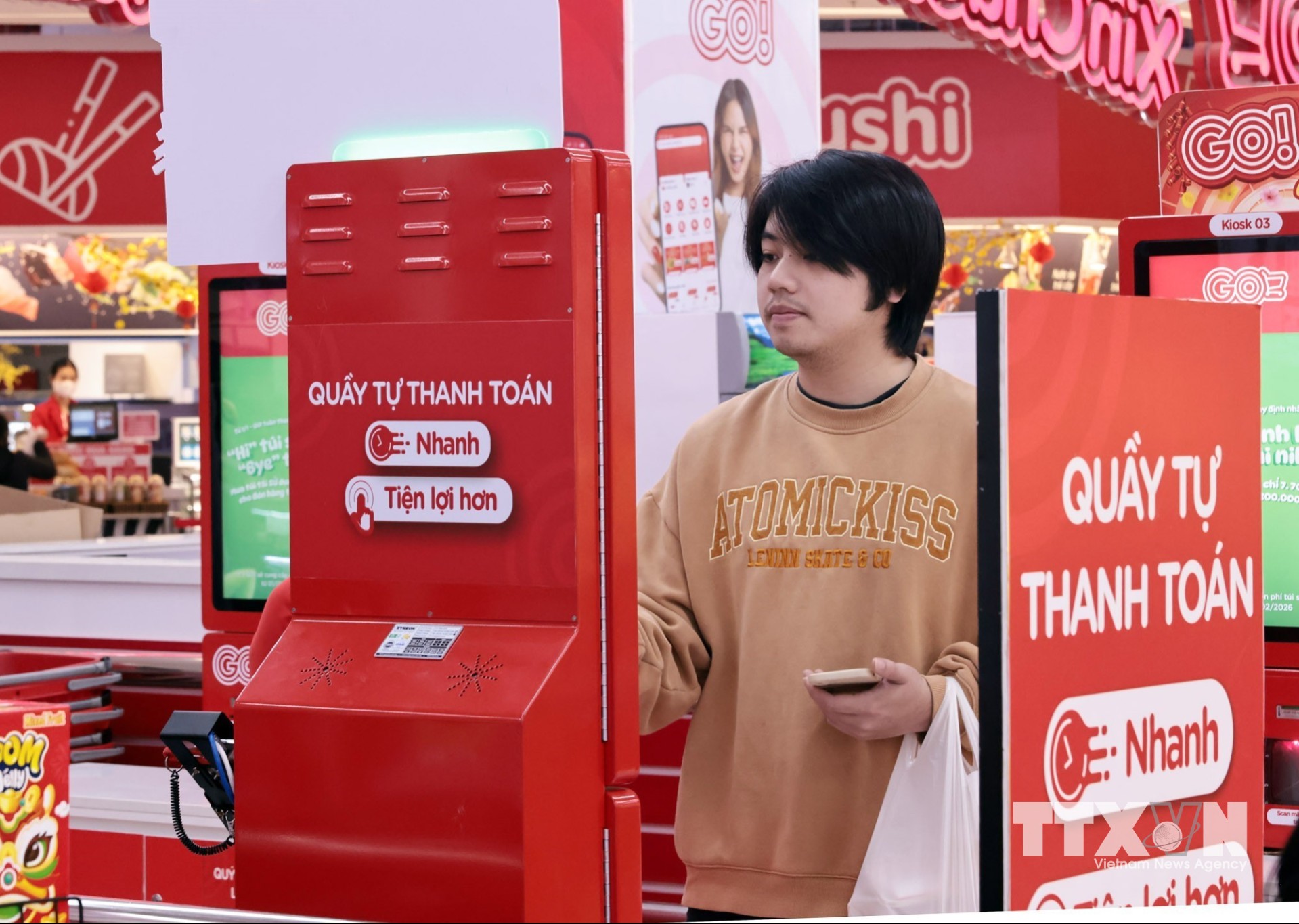Khánh hàng dễ dàng tự làm các thao tác kiểm hàng, quét mã hàng và thanh toán thông qua quầy thanh toán tự động tại hệ thống siêu thị GO!. (Ảnh: Trần Việt/TTXVN)